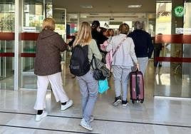 Los vecinos realojados, con sus maletas, hacia la reunión con la concejal de Servicios Sociales.