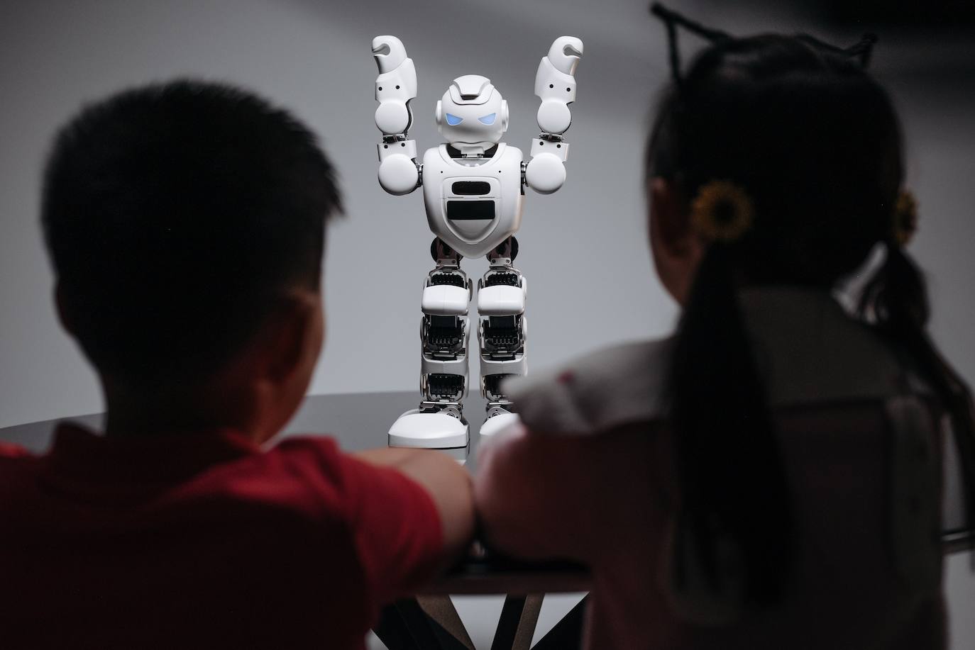 Dos niños juegan con un robot.