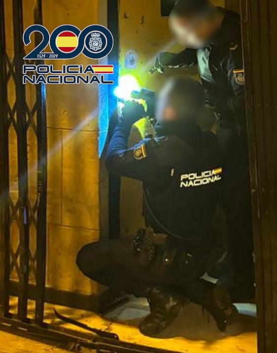 Los agentes inspecionan las cerraduras del local asaltado.