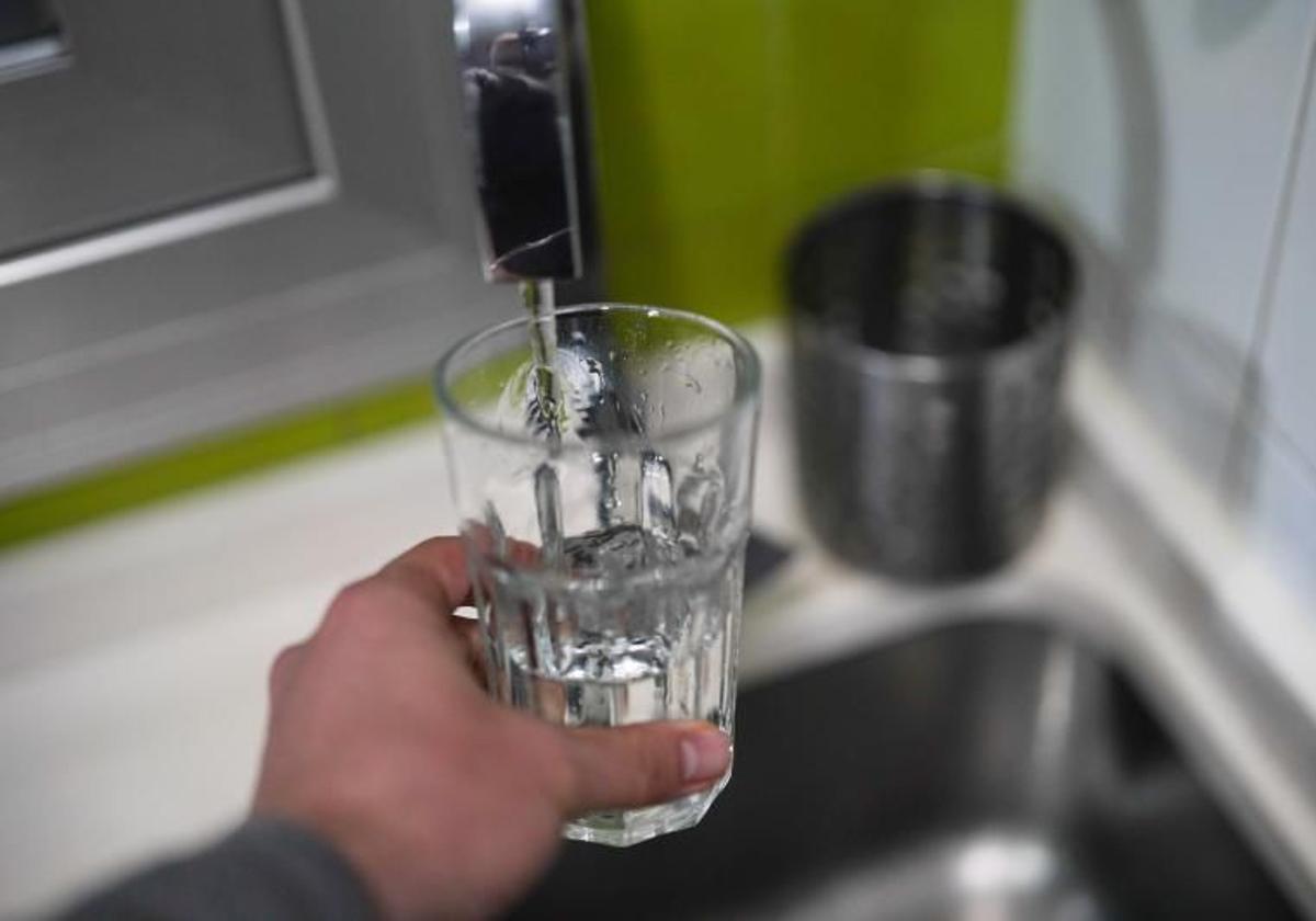 Una persona se llena un vaso de agua del grifo.