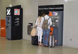 Dos usuarios adquiriendo un título de transporte para el TRAM d'Alacant.