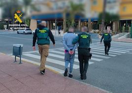 Los guardias civiles custodian al detenido.