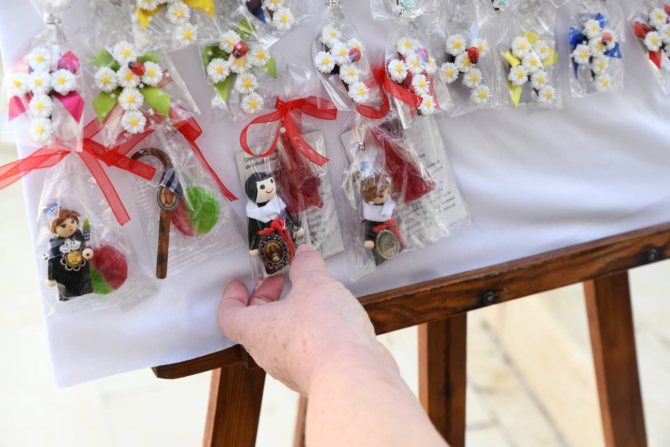 Broches de dama de mantilla, gayatos con la Santa Faz y costaleros de la Hermandad de Santa Cruz.