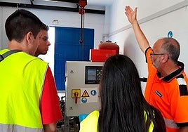 Técnicos de Hidraqua enseñan el funcionamiento de una máquina a unos alumnos.
