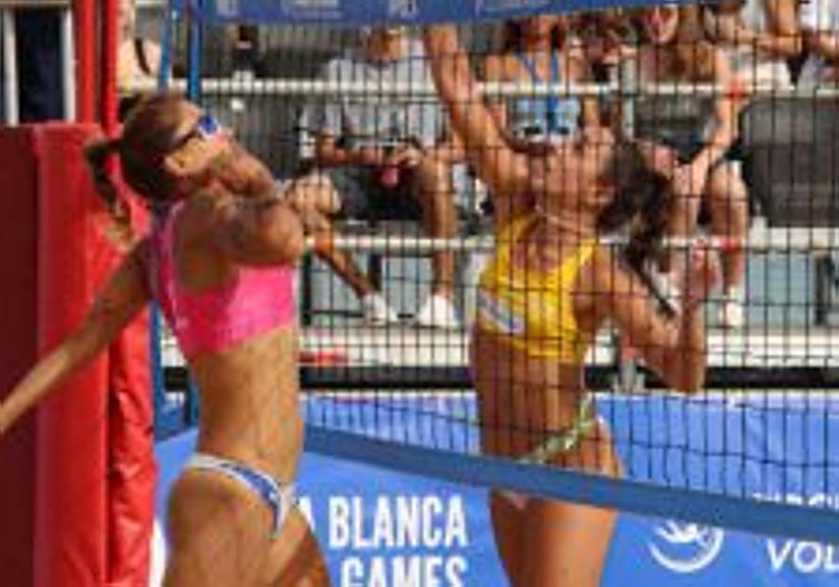 Dos jugadoras de voley playa, en pleno remate.