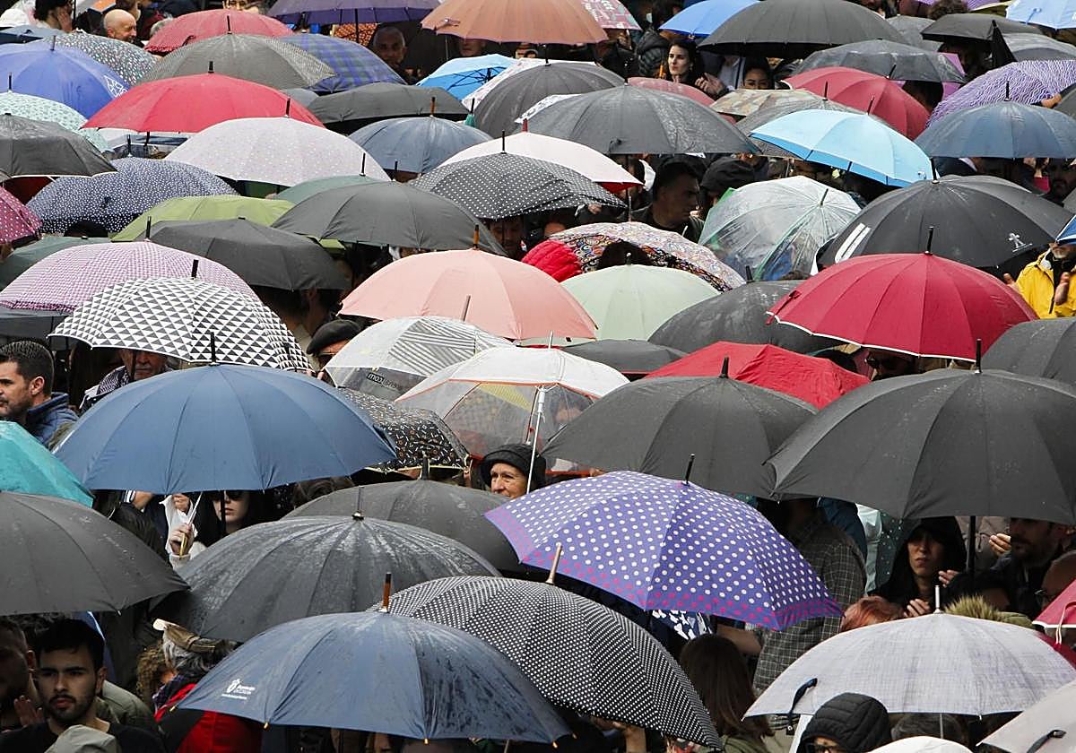 Multitud con paraguas.