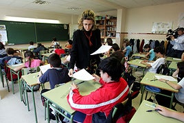 Docente entregando exámenes a sus alumnos.