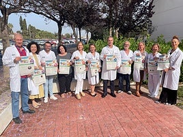 Profesionales muestran los carteles editados para los nueve centros de salud del Departamento Alicante-Sant Joan d'Alacant.