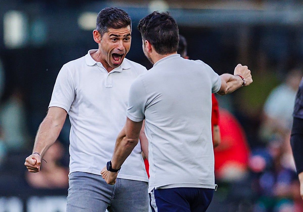 Antonio Hidalgo celebra una victoria del Huesca con uno de sus ayudantes.