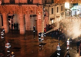 Efectivos de Bomberos bañan al público, durante la Cremà.