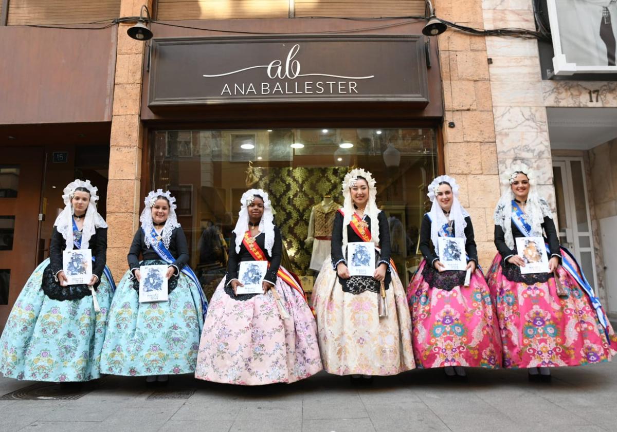 Imagen principal - Belleas y dames d'honor de Carrer Sant Vicent con el llibret y bocetos de sus hogueras.