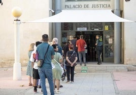 Varias personas haciendo cola en el Palacio de Justicia de Alicante.