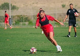 José Artiles conduce el balón ante la mirada de Torrecilla.