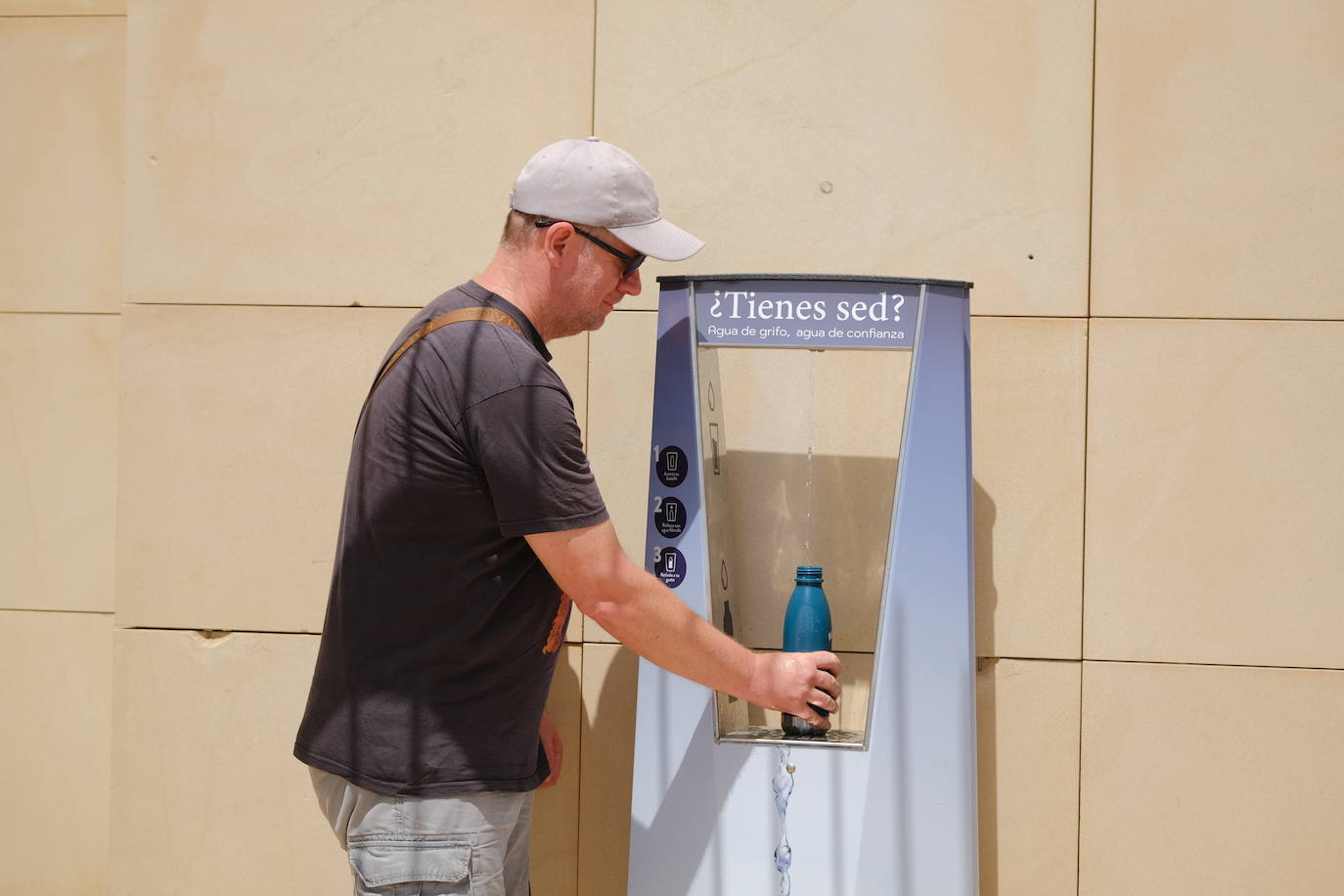 Imagen secundaria 1 - 1. El termómetro que marca la temperatura en la playa del Postiguet. 2. Un hombre rellena su botella de la fuente de agua fría del arenal alicantino. 3 Una persona bebe agua para refrescarse. 