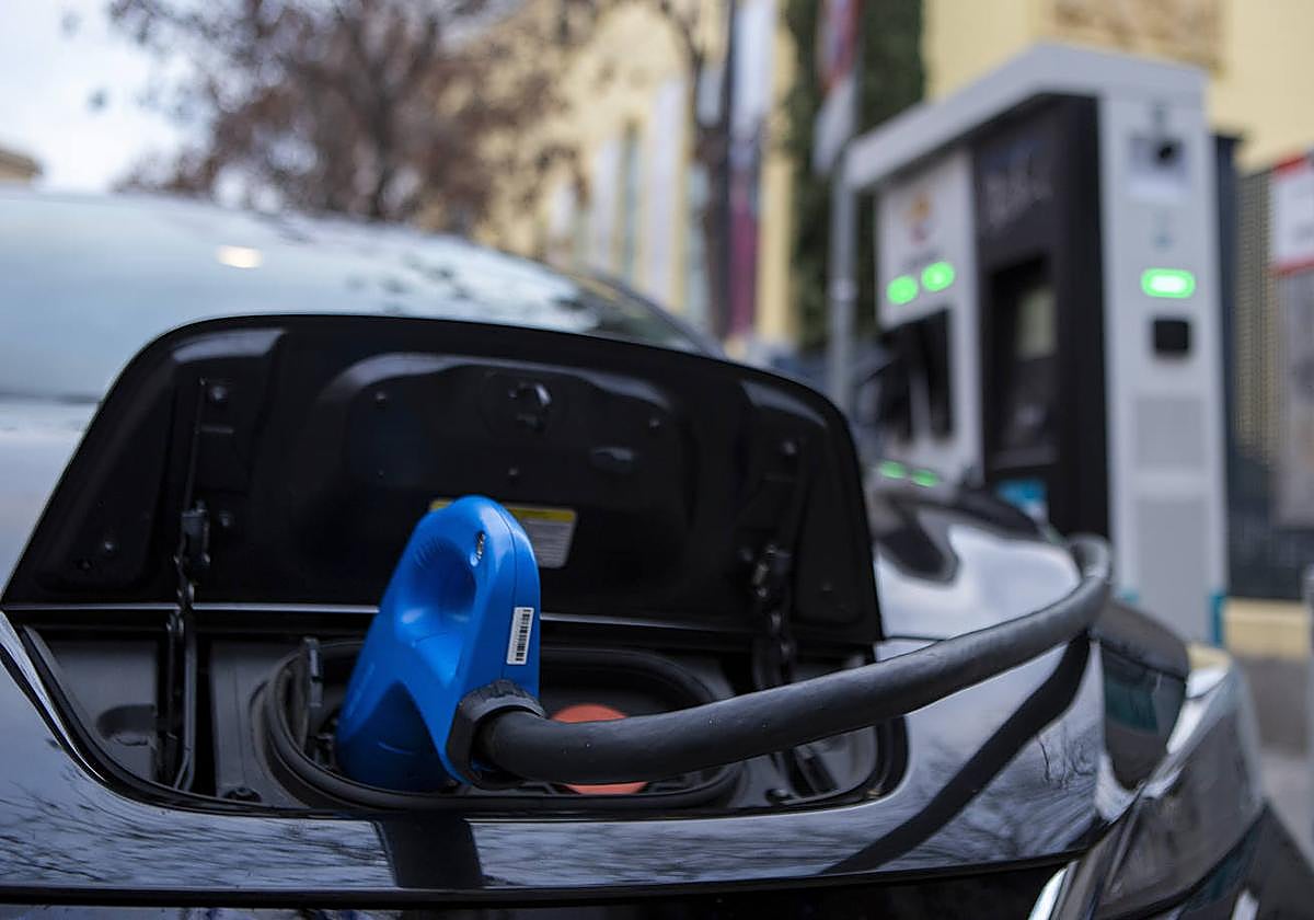 Un coche eléctrico recarga en una estación.