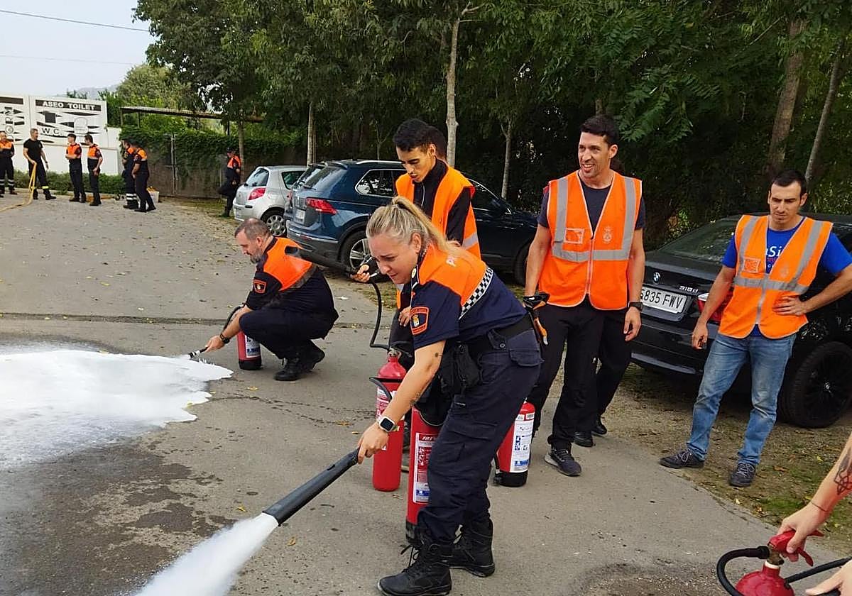 Miembros del cuerpo de Protección Civil usando extintores.