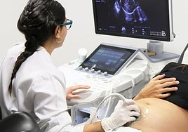 Ginecóloga pasando revisión a una paciente embarazada