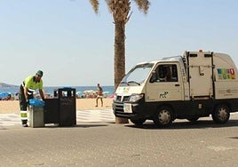 Un operario recoge la basura en una papelera de la playa de Levante