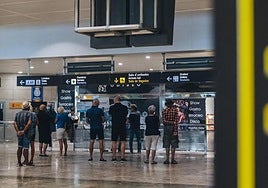 Varios pasajeros esperan en el aeropuerto de Alicante.