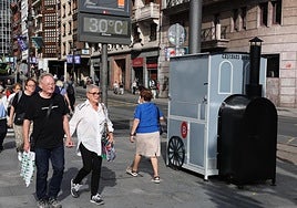 Una pareja pasa por delante de un puesto de castañas asadas.