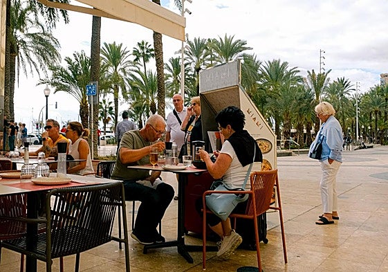 Turistas almorzando en una terraza de la Explanada de Alicante.