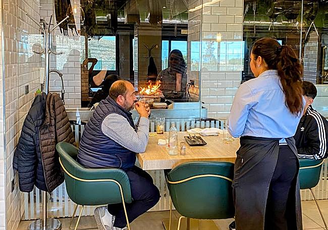 Salón con el fuego de donde se hacen los arroces de fondo.