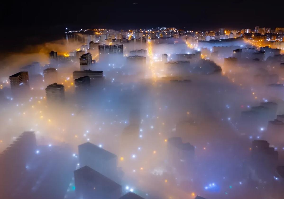 Imágenes de la playa de San Juan enguillada por la niebla.