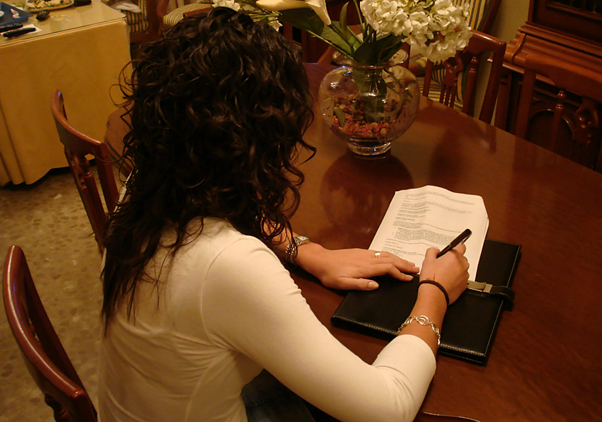 Una mujer firma su testamento, en una imagen de archivo.