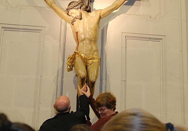 Dos de los participantes en la iniciativa tocan una imagen en la concatedral de San Nicolás.