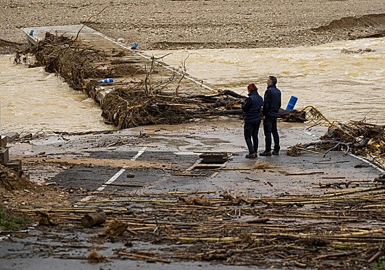 Una pareja observa la crecida del río en Castellón.