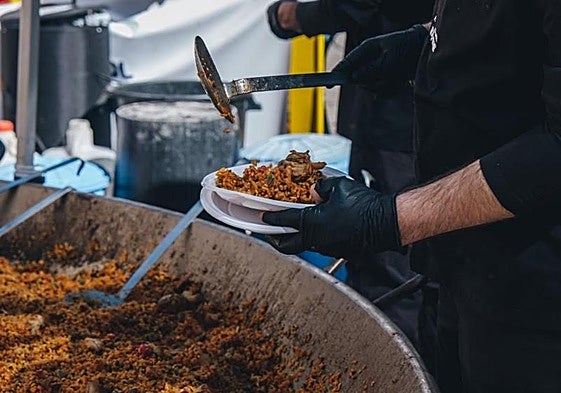 Un cocinero sirve un plato de arroz.