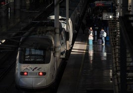 Varias personas junto a un AVE estacionado en la estación de Atocha-Almudena Grandes.