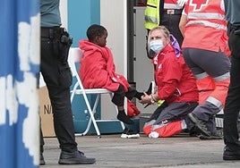 Personal de Cruz Roja atiende a un menor llegado en patera en Canarias.