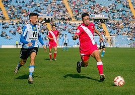 Javi Moreno persigue a un jugador del Sevilla Atlético.