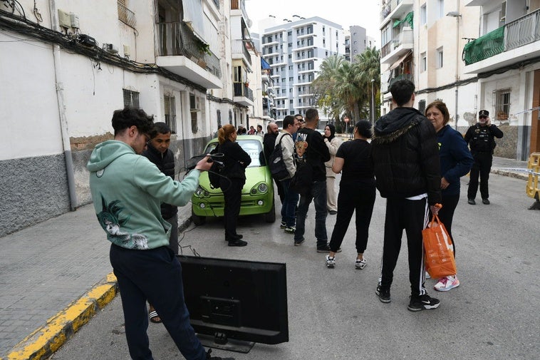 Residents gather around the cordoned-off blocks.