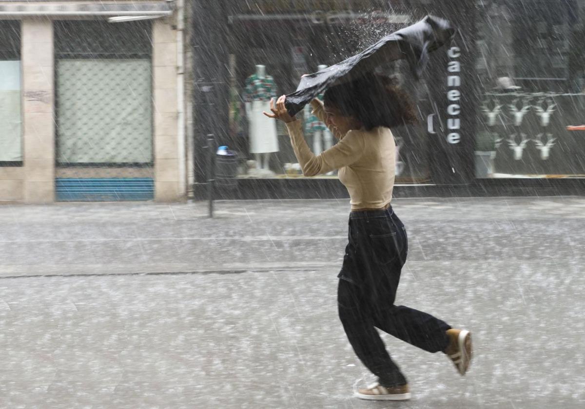Una joven intenta protegerse del granizo.