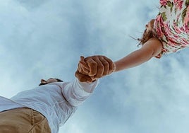 Una pareja pasea cogida de la mano.