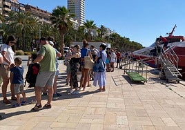 Los turistas esperan para entrar en las embarcaciones.