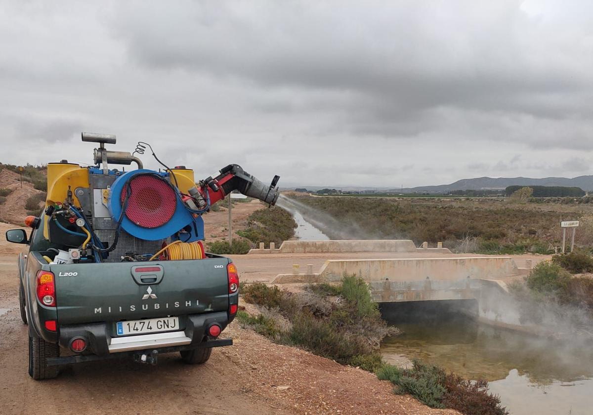 A truck fumigates around the wetland areas.