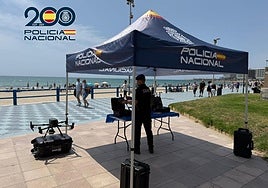 Un agente de la Unidad de Medios Aéreos con uno de los drones en la playa del Postiguet.