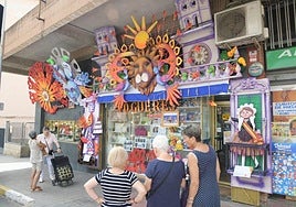 Vecinos de Virgen del Remedio admiran el escaparate de Autoservicio del Hogar.