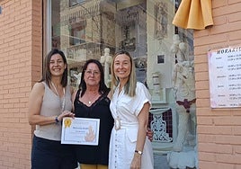 Las propietarias de la mercería recibe el premio de la concejal de Comercio, Lidia López (d).