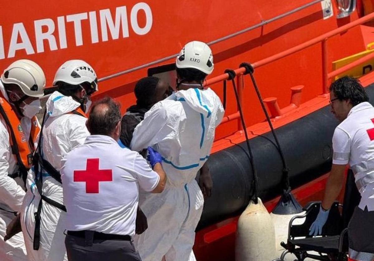 Miembros de Cruz Roja atienden a una persona a su llegada al puerto de Alicante.