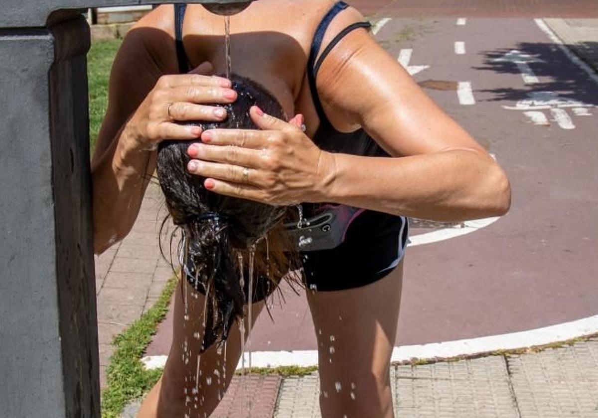 A woman cools off in a fountain to combat the heat.