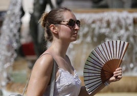 Una viandante se abanica para combatir el calor.