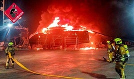 Catamarán ardiendo en el puerto.