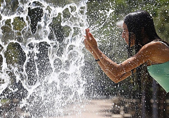 Chica refrescándose en una fuente