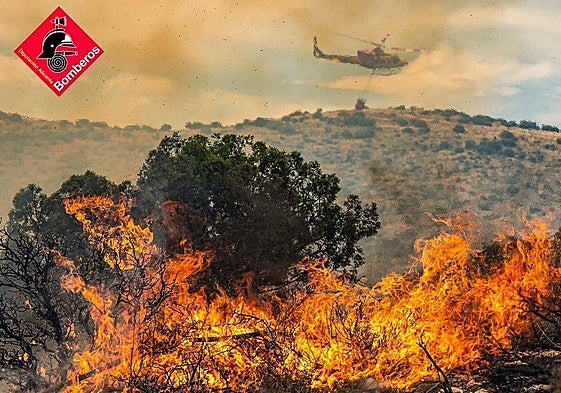 Un helicóptero sobrevuela unas llamas en el incendio de Ibi.