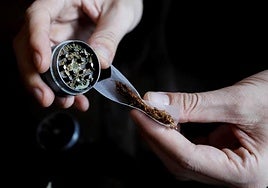 Una persona se lía un cigarro con marihuana.