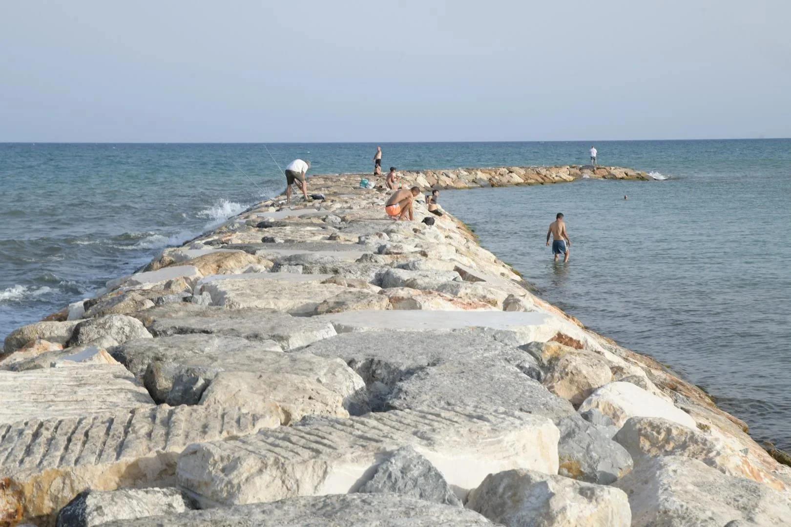 Imagen principal - Coastal authorities deny that the rocks at Postiguet are remnants of the breakwater construction and refuse to demand the contractor to remove them